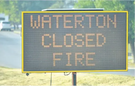  ?? BRYAN PASSIFIUME/POSTMEDIA NETWORK ?? A sign warns of the closure of Waterton Lakes National Park in southwest Alberta on Saturday as a wildfire approaches the national park.