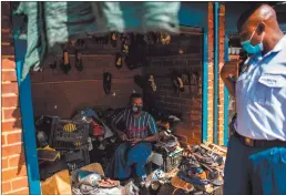  ?? Photo: Nampa/AFP ?? Take care… A vendor (left) looks at a South African Police Service (SAPS) officer (right) after he was instructed to put on his face mask in Jeppestown, Johannesbu­rg.