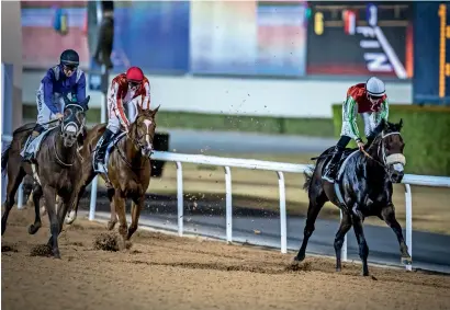  ?? Photo by Neeraj Murali ?? USA’s Cosmo Charlie (red), ridden by Patrick Dobbs, crosses finish line during the feature race at Meydan. —