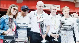  ??  ?? Mercedes-AMG’s British driver Lewis Hamilton (2nd left), and Mercedes-AMG’s German drive Nico Rosberg (2nd right), celebrate with team members after the Spanish Formula One Grand Prix on May 11, at the Circuit de
Catalunya in Montmelo on the outskirts...