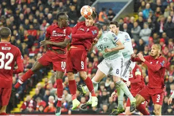  ??  ?? Liverpool’s midfielder Roberto Firmino (centre) wins a defensive header during the UEFA Champions League round of 16, first leg match against Bayern Munich at Anfield stadium in Liverpool, north-west England. — AFP photo