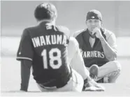  ?? TONY GUTIERREZ/The Associated Press ?? Seattle Mariners pitchers Hisashi Iwakuma and Felix Hernandez stretch during spring training in
Peoria, Ariz.