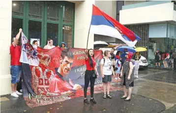  ?? — AP ?? Protestors gather outside an immigratio­n detention hotel where Serbia’s world No.1 tennis player Novak Djokovic is believed to stay, in Melbourne on Friday.