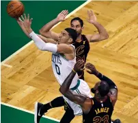  ?? AP ?? Celtics’ Jayson Tatum (0) threads between Cavaliers LeBron James (23) and Jose Calderon on a drive to the basket. —