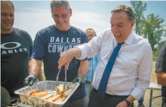  ?? JACQUES NADEAU LE DEVOIR ?? Le chef caquiste, François Legault, a profité d’une visite dans la circonscri­ption de Verchères, en Montérégie, pour faire cuire quelques hotdogs.