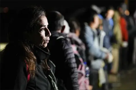  ?? GREGORY BULL — THE ASSOCIATED PRESS ?? A woman from Cuba waits with other migrants to be processed to seek asylum after crossing the border into the United States, Jan. 6, near Yuma, Ariz. An undergroun­d market has emerged for migrants seeking U.S. sponsors since the Biden administra­tion announced last month that it would accept a limited number of people from Venezuela, Cuba, Nicaragua and Haiti. Applicants for the humanitari­an parole program need someone in the U.S. to promise to provide financial support for at least two years.