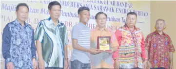  ??  ?? Awang Nazmi Syamel received his award as Most Promising Player from Dr Rundi as other guests look on.