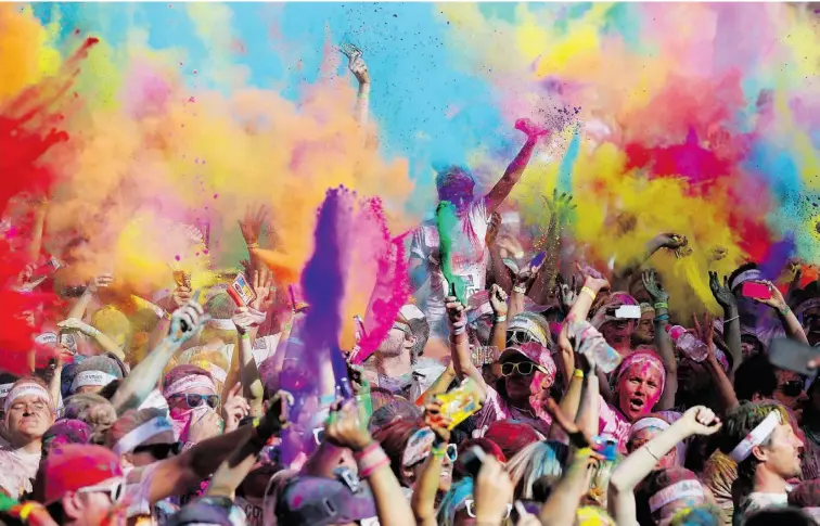  ?? CHRIS HYDE/ GETTY IMAGES ?? Competitor­s celebrate completing the Colour Run earlier this month in Gold Coast, Australia. The Color Me Rad race takes place in Edmonton July 6 and 7.