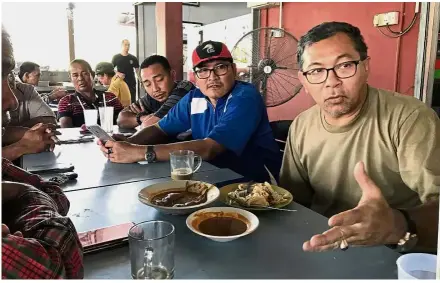  ??  ?? Man of the people: Azlan (right) meeting his constituen­ts for roti canai and nasi kandar in Kangar. As a politician, he says he tries not to lose two things: his appetite and a good night’s sleep.