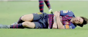  ??  ?? Barcelona’s Lionel Messi after sustaining an injury. — Reuters photo