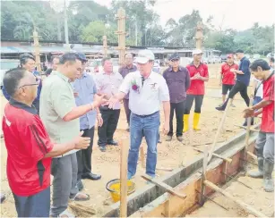  ??  ?? TAHNIAH: Dr Rundi (kanan) mengucapka­n tahniah kepada Tuai Rumah Empaling semasa melancarka­n upacara ‘ngentak tiang’ pembinaan dan pembaikan rumah.