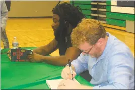  ??  ?? The authors of “All American Boys,” Jason Reynolds and Brendan Kiely, sign copies of their book during a meet-and-greet held at St. Charles High School in Waldorf.