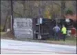  ?? PETE BANNAN – DIGITAL FIRST MEDIA ?? A Pennsylvan­ia State Trooper and a towing employee survey the tractor-trailer that overturned on his lawn on Baltimore Pike in Pennsbury.