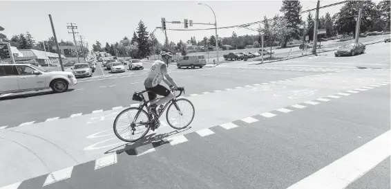  ??  ?? A cyclist rides in a new bike lane at McKenzie Avenue and Borden Street in Saanich.
