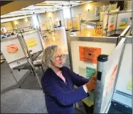  ??  ?? Shirley Emery puts voting instructio­ns into voting booths Monday at a polling station at the American Legion in Brattlebor­o, Vt. (AP/The Brattlebor­o Reformer/Kristopher Radder)