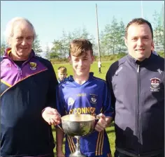  ??  ?? Daniel Bolger, the Ballinastr­agh Gaels captain, with John O’Neill of Coiste na nOg and Brian Carty, representi­ng People Newspapers.