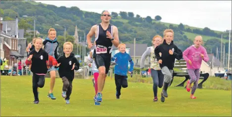  ??  ?? Craig Wood is joined by junior triathlon club members as he heads for the finish line.