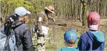  ??  ?? Ranger Carsten Richter erklärt den Tour-Teilnehmer­n das vielschich­tige Ökosystem Wald.