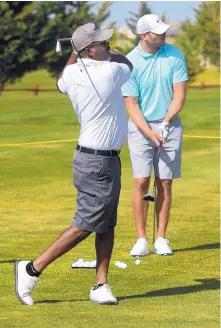  ?? GREG SORBER/JOURNAL ?? Class of 2018 Pro Football Hall of Famer Brian Urlacher, right, and singer Darius Rucker hit balls at the Santa Ana Golf Course driving range durng the New Mexico Grande Slam.