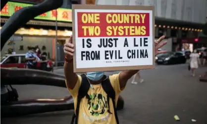  ??  ?? A protester in Hong Kong holds a placard on Sunday at a march that was disrupted by riot police. There are fears China will enact a harsh new national security law in in the coming days. Photograph: Ivan Abreu/SOPA Images/REX/Shuttersto­ck