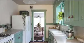  ??  ?? Hayley Francis sits at a vintage table under a vintage chandelier from craigslist. Originally, a chandelier dangled between the living and dining areas, but Francis “moved it to make it feel like two rooms.” The rattan chairs, from The Mine, “will be...