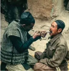  ?? BILL HANSON/PHOTO KATHMANDU ?? This 1968 photo being exhibited at Photo Kathmandu shows a wandering dentist, with a cigarette perched on his lips, pulling out a tooth to relieve the pain of a man on the road from Chainpur to Namche. Moments later, the dentist and patient went their...