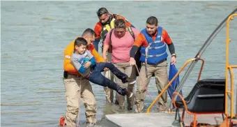  ?? GETTY IMAGES ?? CROSSED UP: Members of a Mexico-based migrant rights group, rescue a Central American migrant child and woman trying to cross the Rio Bravo, which divides Eagle Pass, Texas, and Piedras Negras, Mexico, Thursday.