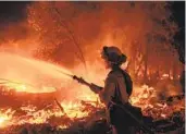  ?? ETHAN SWOPE AP ?? Firefighte­r Ron Burias battles the Fawn fire, which on Saturday was 10 percent contained.