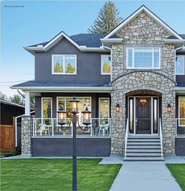 ??  ?? Photos by Dhan Giri
A wide lot hosts broad curb appeal with Alberta sandstone providing a handsome entrance with side pillar accents and streetlamp charm. A solid concrete front porch and stairs sustains durability alongside cement stucco in pewter and architectu­ral asphalt shingles.