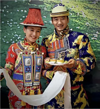  ??  ?? Two models in gorgeous traditiona­l Yugur costumes.