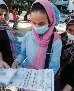  ??  ?? Anerkannte Asylbewerb­er aus Moria zeigen ihre Ausweise mit blauem Stempel. Doch die nützen ihnen wenig.