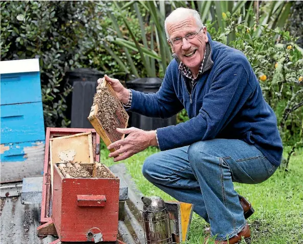  ?? PHOTO: MARION VAN DIJK/ FAIRFAX NZ ?? Urban beekeeper Nigel Costley with one of his beehives in the backyard in the Brook.