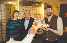  ??  ?? A 1920s carousel giraffe. From left, Angela Hicks, Nigel Havers and valuation expert Simon Bower.