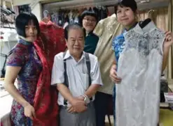  ??  ?? Taiwanese “qipao” maker Lin Chin-te (center) and his students posing for photos at his studio in Taipei.