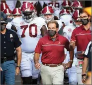  ?? (AP/L.G. Patterson) ?? Alabama Coach Nick Saban (front) led his team to victory over Georgia last week, hours after a third negative covid-19 test. The dean of the Brown University School of Public Health, Dr. Ashish Jha called it “a reminder of the stark disparity between the haves and have-nots.”