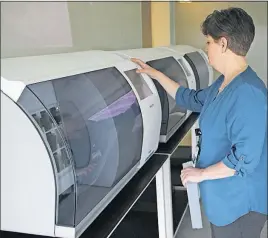  ?? MEDICAL CENTER] [PHOTOS PROVIDED BY OHIO STATE UNIVERSITY WEXNER ?? Pathology slides are placed into a machine that scans and digitizes them, creating an image that easily can be viewed and shared by pathologis­ts around the world.