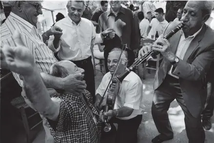  ??  ?? Musicians and dancers at a festival in Ganadio, a village in the region of Epirus in northweste­rn Greece, 2000