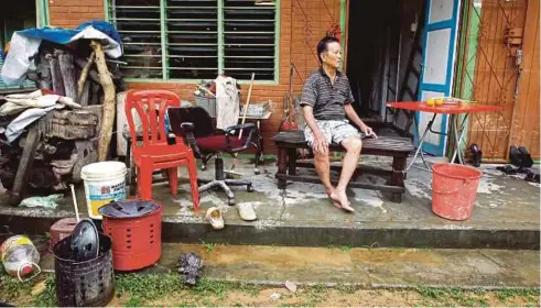  ?? PIC BY MUHD ASYRAF ?? Ho Seng Kuen taking a break after cleaning his house in Sungai Lembing, Kuantan, yesterday