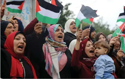  ?? AP ?? Women wave Palestinia­n flags and chant slogans during a protest at the Unknown Soldier Square in Gaza City on Wednesday. —