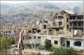  ?? Associated Press ?? A Syrian National flag hangs out of a damaged building at the mountain resort town of Zabadani in the Damascus countrysid­e, Syria on May 18. The Syrian government on Tuesday dismissed White House allegation­s that it was preparing a new chemical weapons...