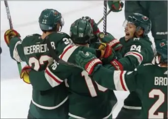  ?? JIM MONE — THE ASSOCIATED PRESS ?? The Wild’s Matt Dumba, right, and teammates celebrate a goal against Flyers goalie Brian Elliott by Nino Niederreit­er, left, during the first period Tuesday night in St. Paul, Minn.