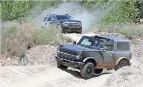  ?? ERIC SEALS/USA TODAY NETWORK ?? A 2021 Ford Bronco four-door follows a Bronco two-door around the course during the 2020 Bronco Day event at the soon-to-be-opening Holly Oaks Off-road Park in Holly, Mich.