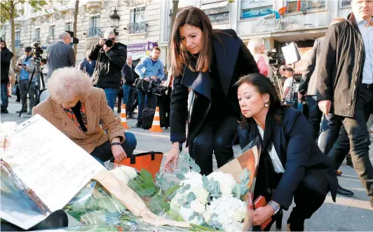  ?? photo AFP ?? La mairesse de Paris, Anne Hidalgo, et la mairesse du huitième arrondisse­ment, Jeanne D'hauteserre, ont déposé hier des fleurs pour rendre hommage au policier tombé sous les balles du tueur, sur les Champs-Élysées jeudi soir.