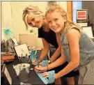  ?? / Spencer Lahr ?? Alexis Massey, 12, and Courtney Gribble write their names on raffle tickets Saturday.