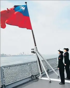  ?? MANDY CHENG / AFP ?? LA VANGUARDIA
Dues marineres de Taiwan retent honors a la bandera del seu país