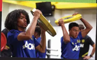  ??  ?? Doing the hard yards: Marcos Rojo and Andreas Pereira (above) take a break for water during United’s training camp, while Tahith Chong and Jesse Lingard (right) build strength in the gym