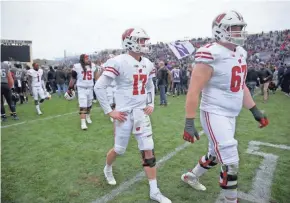  ?? MIKE DE SISTI / MILWAUKEE JOURNAL SENTINEL ?? Quarterbac­k Jack Coan (17) and offensive lineman Jon Dietzen walk off the field after Wisconsin's 31-17 loss to Northweste­rn on Saturday. Coan was 20 of 31 for 158 yards in his first start.