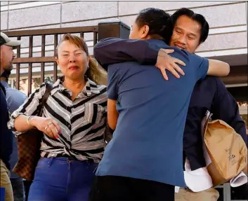  ??  ?? In this June 12 photo, Ammala Mingsouan embraces family outside the building that houses Immigratio­n and Customs Enforcemen­t and the Atlanta Immigratio­n Court after being released from ICE custody, in Atlanta.
AP Photo/AndreA SmIth