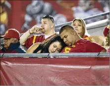  ?? DANNY MOLOSHOK / AP ?? USC fans sleep at the end of a game against Arkansas State in 2015. To keep fans in the stands and those watching on TV or mobile devices engaged, college football leaders are taking steps to shorten game times.