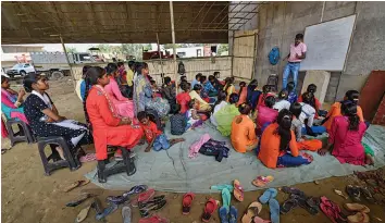  ?? — PTI ?? Students from a slum area, who do not have access to internet facilities and missed their online lessons, attend an open- air class after the authoritie­s closed all schools following the coronaviru­s outbreak at Yamuna Khadar in New Delhi on Saturday.